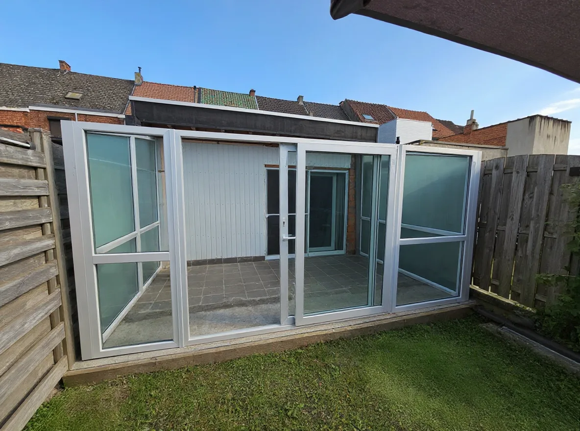 Angle alternatif de la véranda montrant la porte coulissante et la limite du jardin