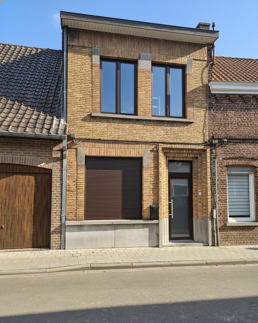 Straatzicht van de vernieuwde gevel met bijpassende kozijnen en rolluik